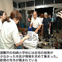 避難所の柏崎小学校には自宅の被害が少なかった市民が情報を求めて集まった。新聞の号外が積まれている)